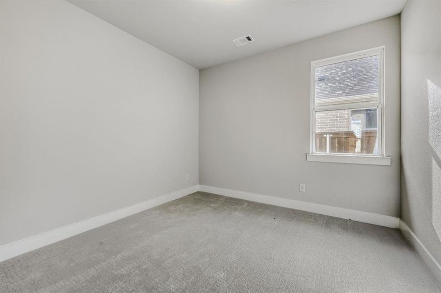Empty room featuring light carpet and baseboards