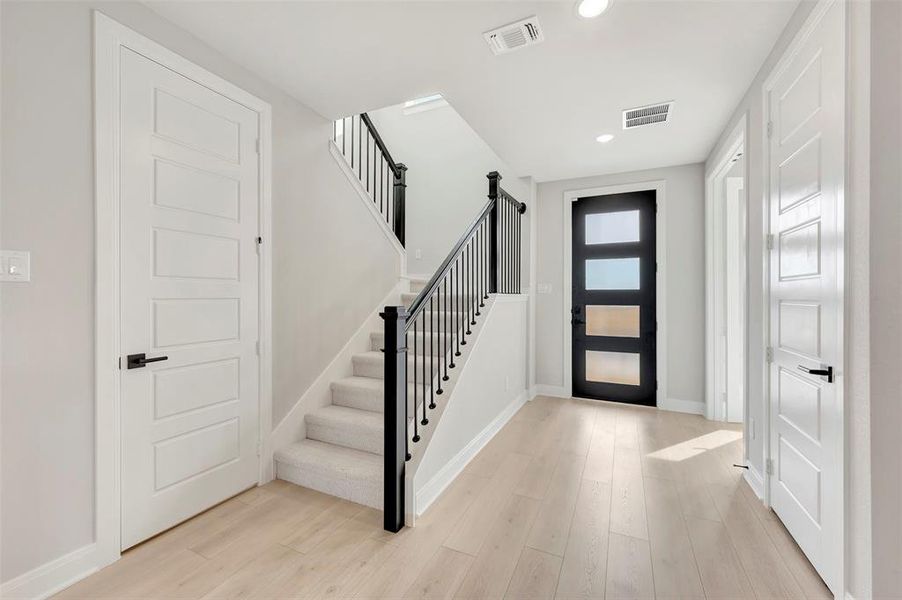 Foyer with light wood-style floors and recessed lighting
