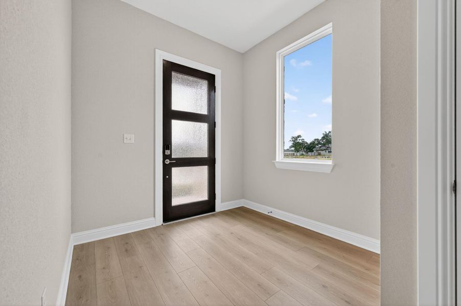 Foyer entrance with baseboards and light wood-style floors