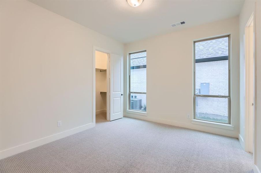 Carpeted empty room featuring plenty of natural light