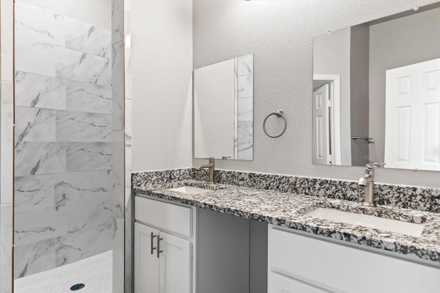 Bathroom with a tile shower and vanity