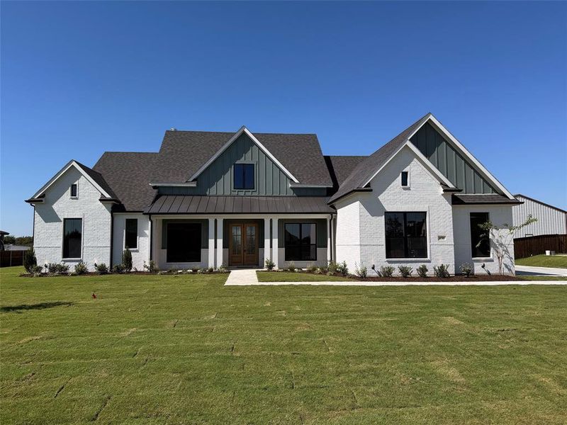 Modern farmhouse style home featuring a front lawn