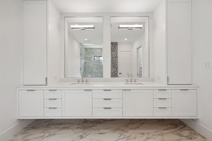 The expansive double vanity with its floating design and sleek white cabinetry & marble countertopscreates a sense of spaciousness, while the large mirrors with integrated lighting enhance thesense of openness and provide ample illumination.