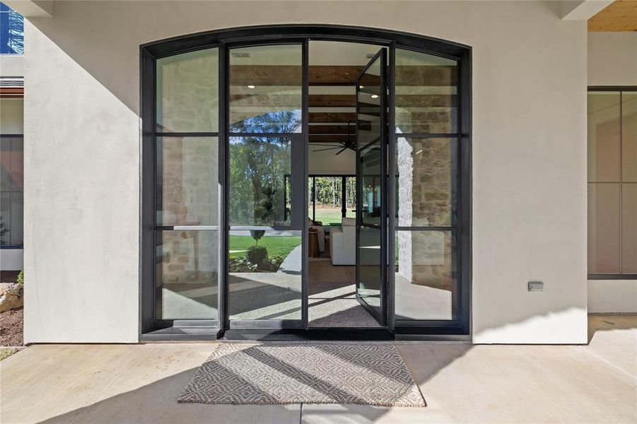 Property entrance with a patio area, stucco siding, and stone siding
