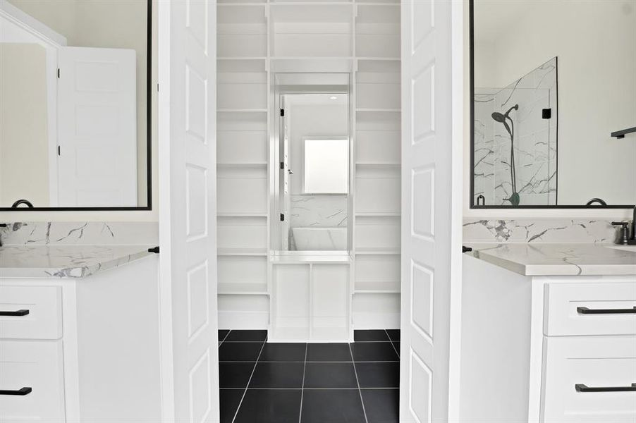 Bathroom with vanity, tile patterned floors, and a tile shower