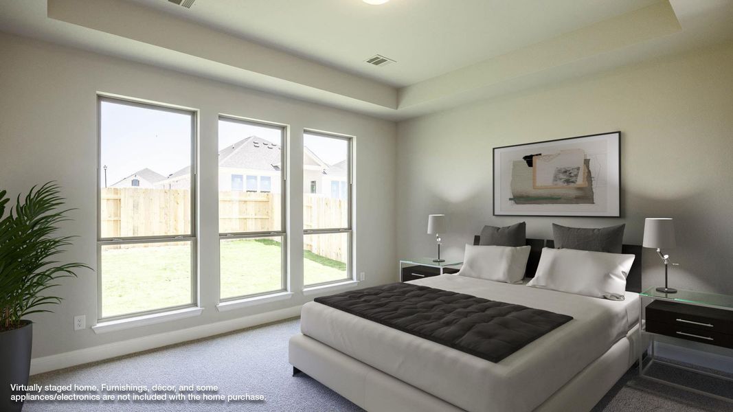 Bedroom with carpet flooring, baseboards, and a tray ceiling Bedroom with carpet flooring, baseboards, and a tray ceiling