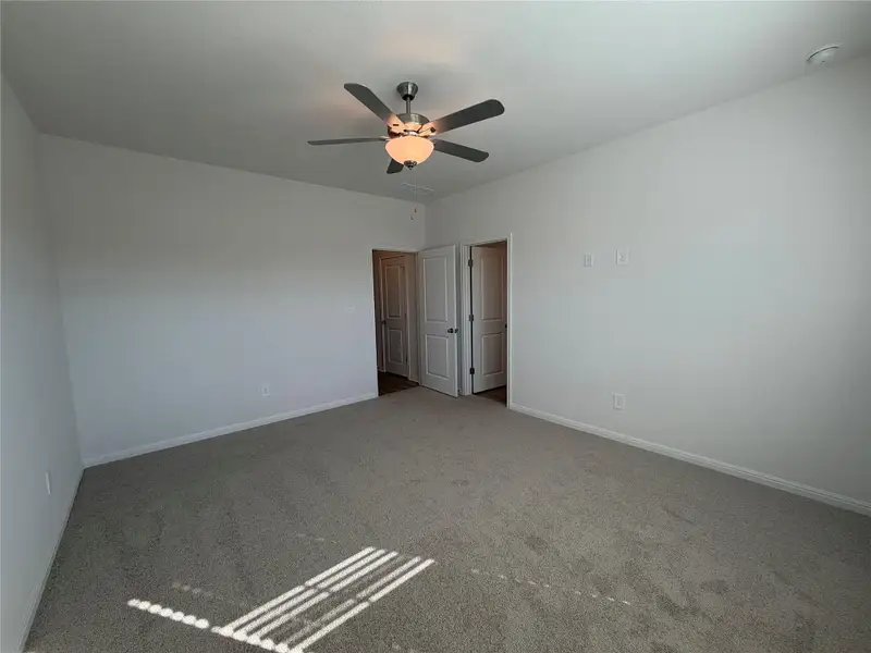 Unfurnished room with carpet and a ceiling fan