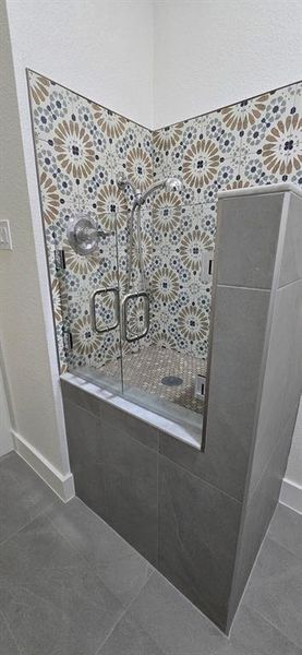 Full bathroom featuring a shower stall and dark tile patterned flooring Full bathroom featuring a shower stall and dark tile patterned flooring