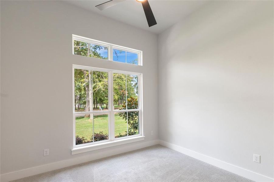 Carpeted empty room featuring ceiling fan