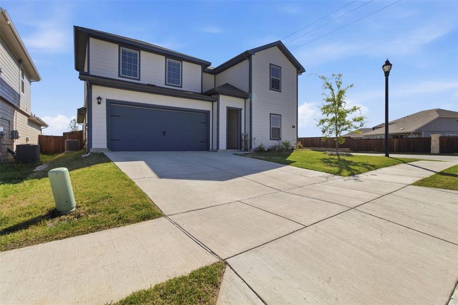 Traditional-style house featuring a garage and concrete driveway Traditional-style house featuring a garage and concrete driveway