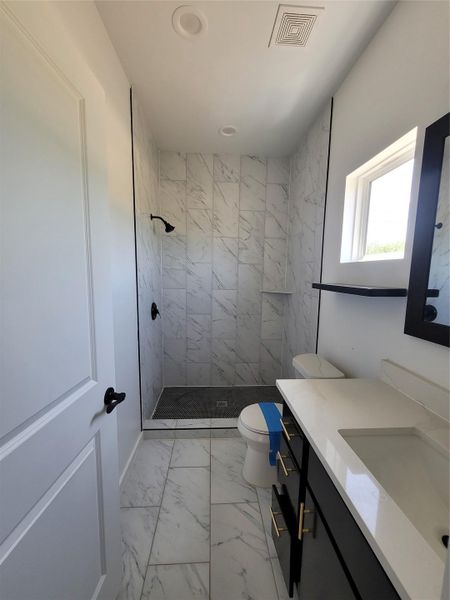 Marble-look tile and a spacious vanity combine in this well-appointed bathroom.