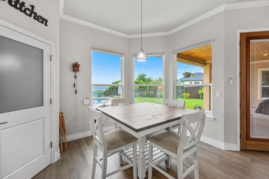 A well-lit dining area offers abundant outdoor views and wood flooring. A well-lit dining area offers abundant outdoor views and wood flooring.