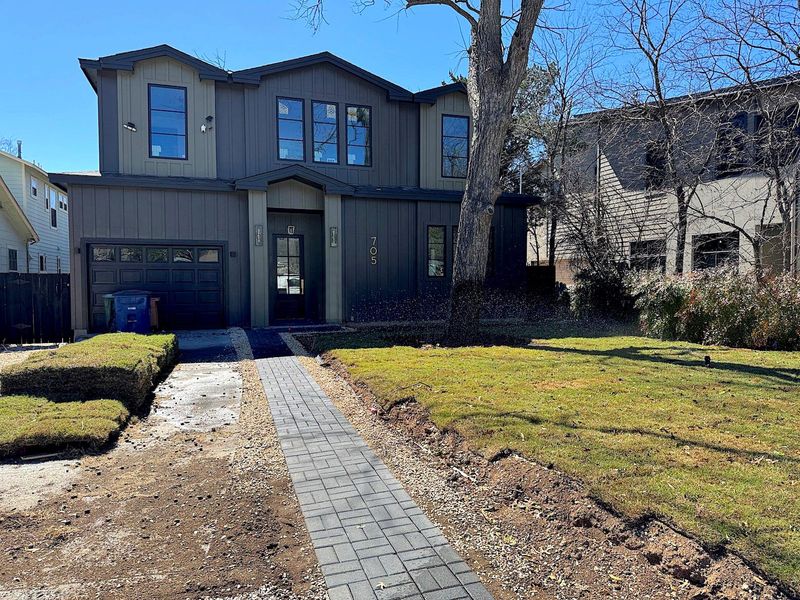 Modern farmhouse style home with driveway, an attached garage, a front lawn, and fence