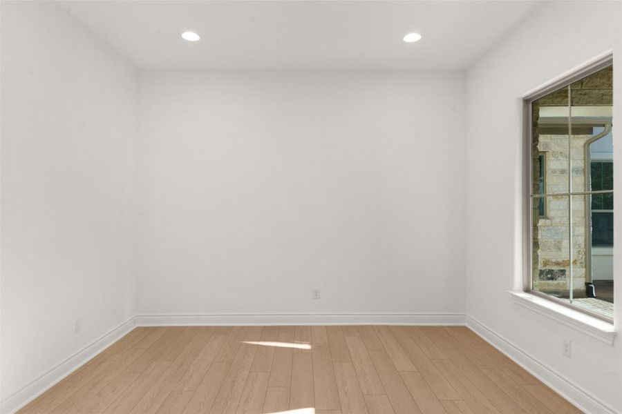 Empty room featuring light wood-style flooring and recessed lighting