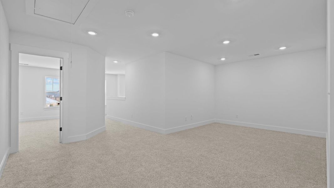 Vibrant carpeted loft offering flexibility as a study nook, game room, or second family space