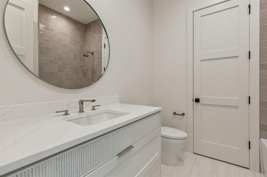 Bathroom with a shower, tile patterned flooring, vanity, and toilet