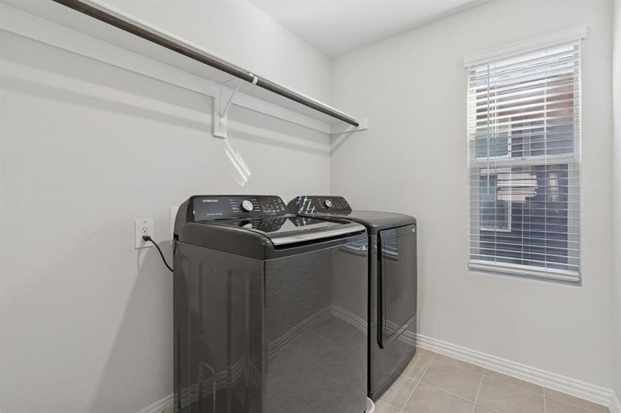 Laundry room with light tile patterned flooring and washing machine and dryer