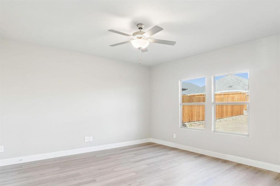 Spare room with light wood finished floors and ceiling fan Spare room with light wood finished floors and ceiling fan