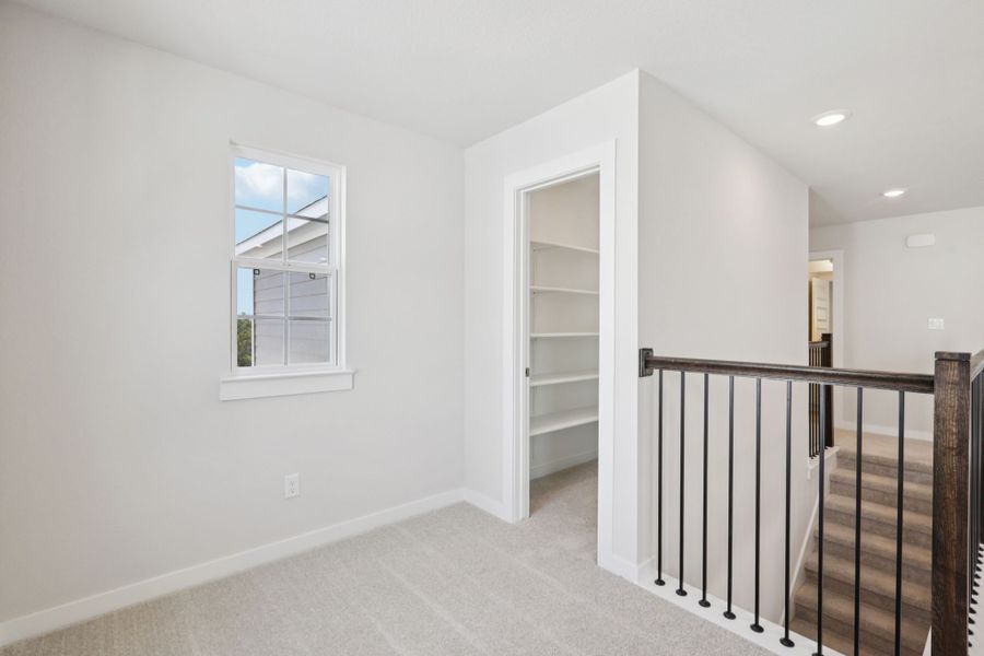 A white room with a black railing.