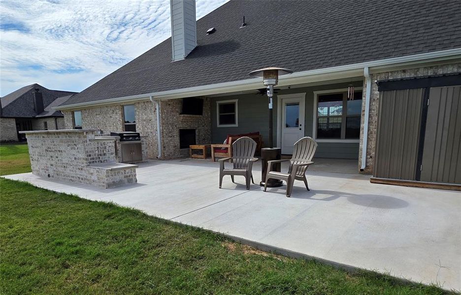 View of patio with an outdoor fireplace and exterior kitchen