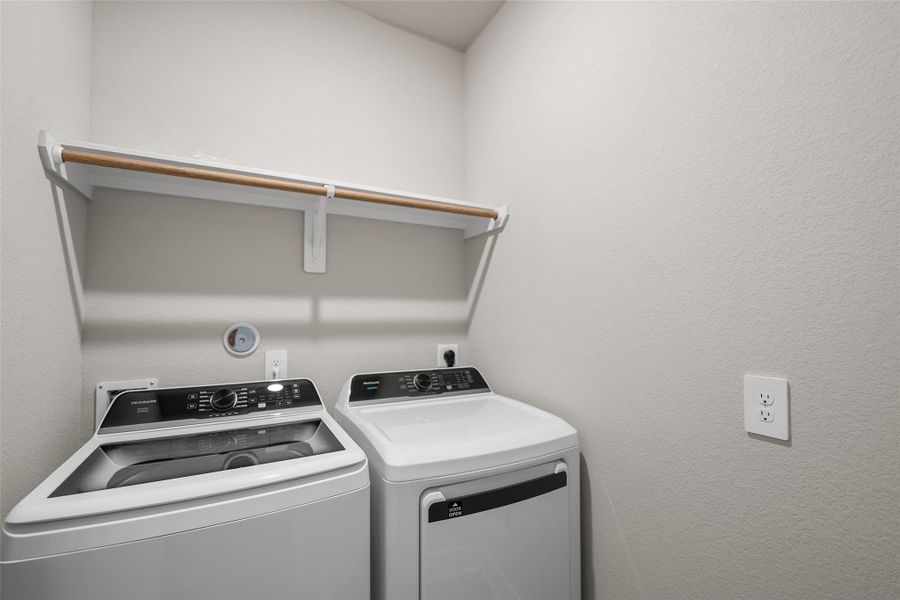 Convenient laundry space with built-in shelving for organization and storage. Convenient laundry space with built-in shelving for organization and storage.