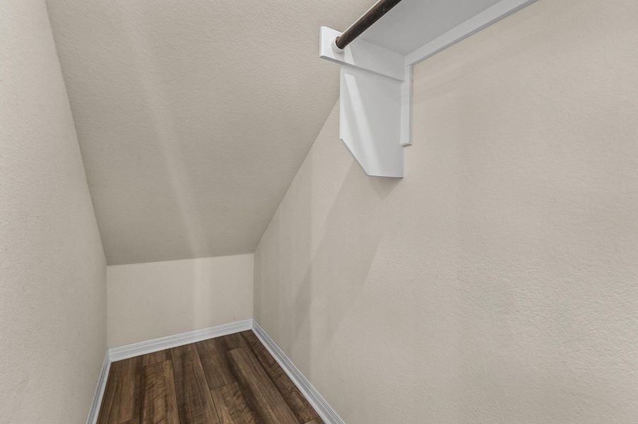 Walk in closet with dark wood finished floors and vaulted ceiling Walk in closet with dark wood finished floors and vaulted ceiling