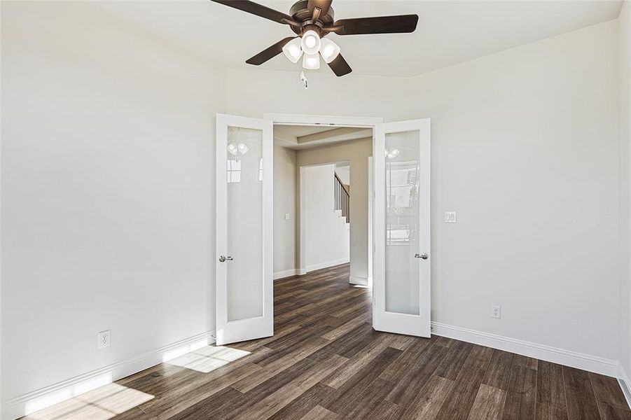 Spare room featuring french doors, dark hardwood / wood-style floors, and ceiling fan