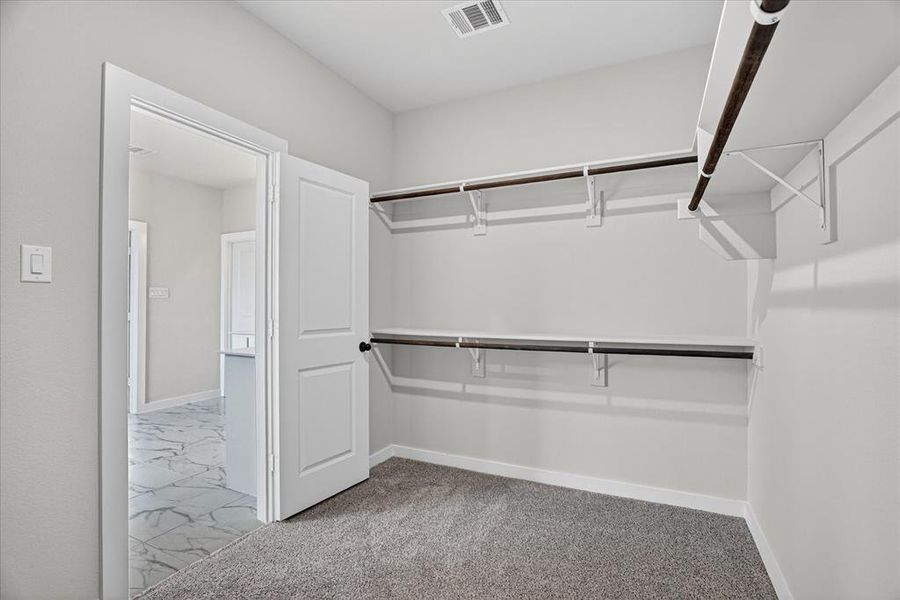 Spacious closet with built-in shelving and hanging rods