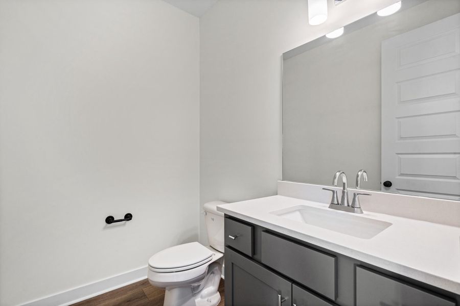 Bathroom vanity with a white countertop and integrated sink, complemented by a brushed nickel faucet Bathroom vanity with a white countertop and integrated sink, complemented by a brushed nickel faucet