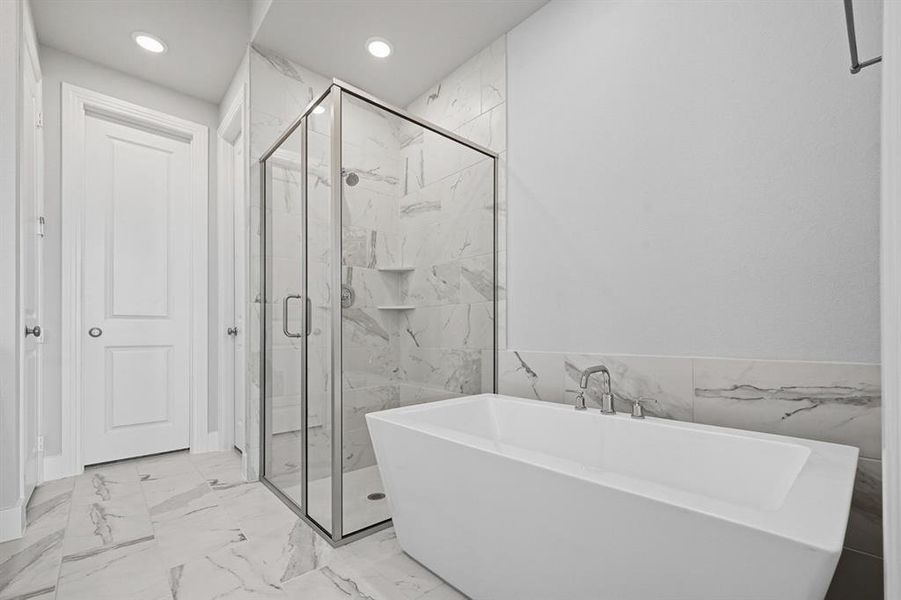 Full bathroom with a marble finish shower, light marble finish flooring, a freestanding tub, recessed lighting, and tile walls