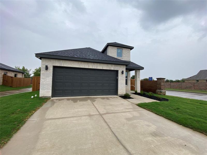 View of front of house featuring a garage and a front lawn