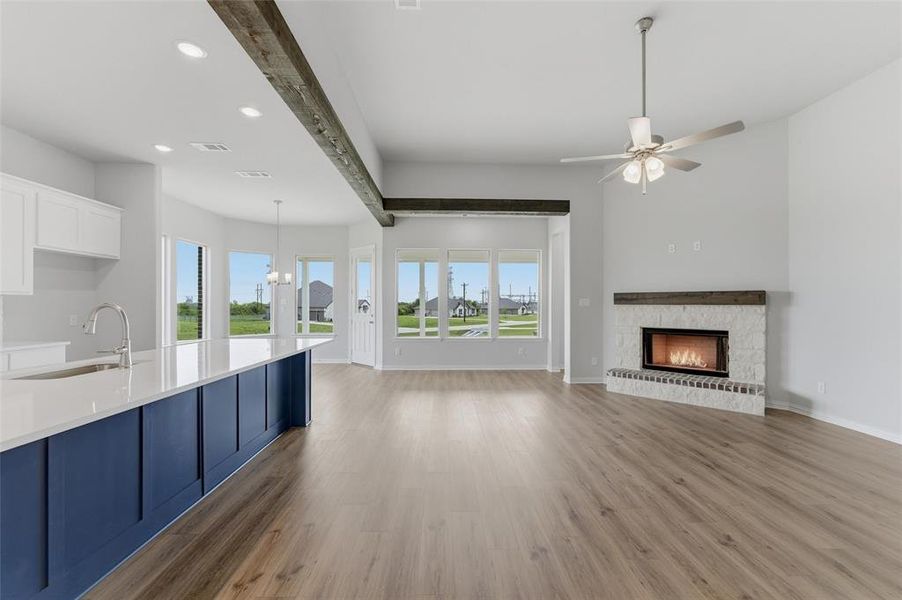 Bright and open living area featuring a fireplace with a stone surround, a ceiling fan, and recessed lighting