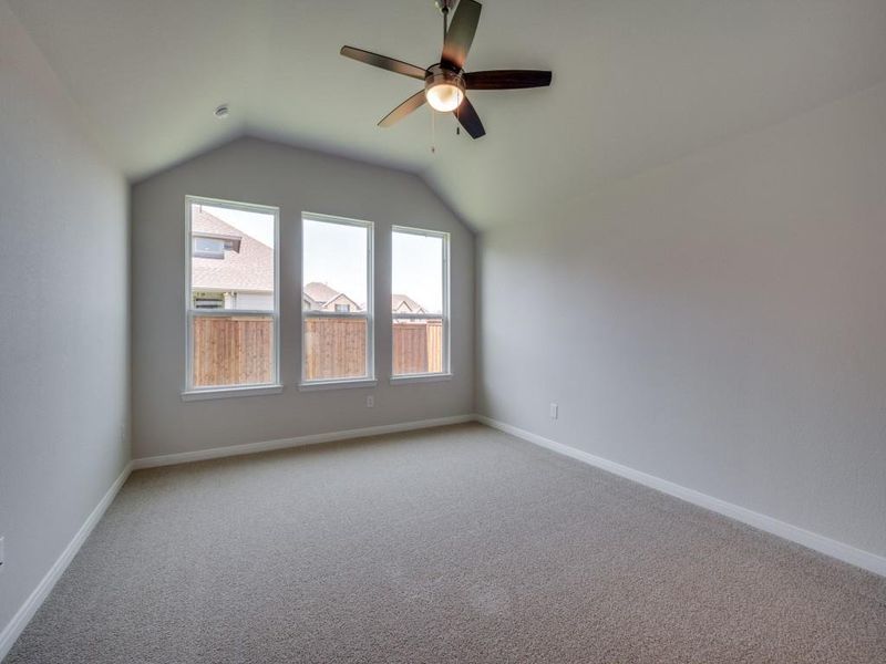 A wall of windows provides a peaceful and relaxing back yard view in this owner's suite.