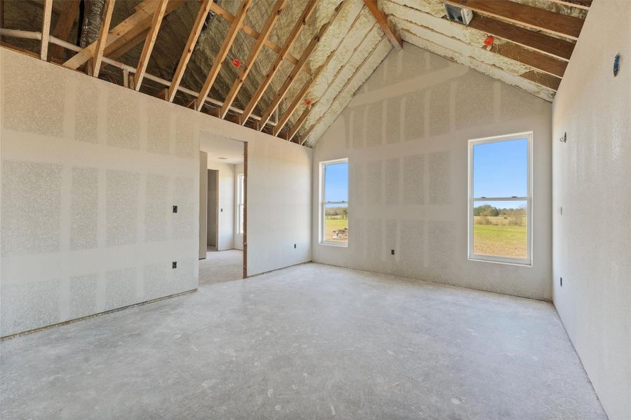 Experience the elegance of a primary bedroom with vaulted ceilings and a cedar beam, featuring large windows for stunning views. Enjoy a luxurious en-suite and a spacious closet conveniently connected to the laundry area. Experience the elegance of a primary bedroom with vaulted ceilings and a cedar beam, featuring large windows for stunning views. Enjoy a luxurious en-suite and a spacious closet conveniently connected to the laundry area.