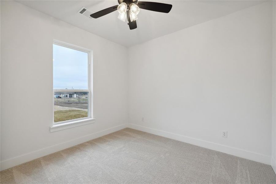 Empty room featuring light carpet and ceiling fan