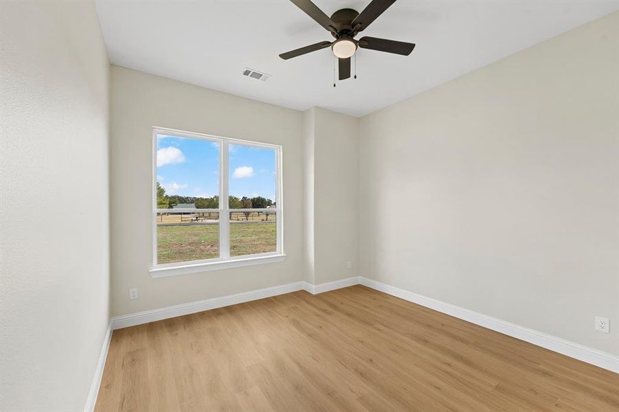 Empty room with light wood finished floors and a ceiling fan