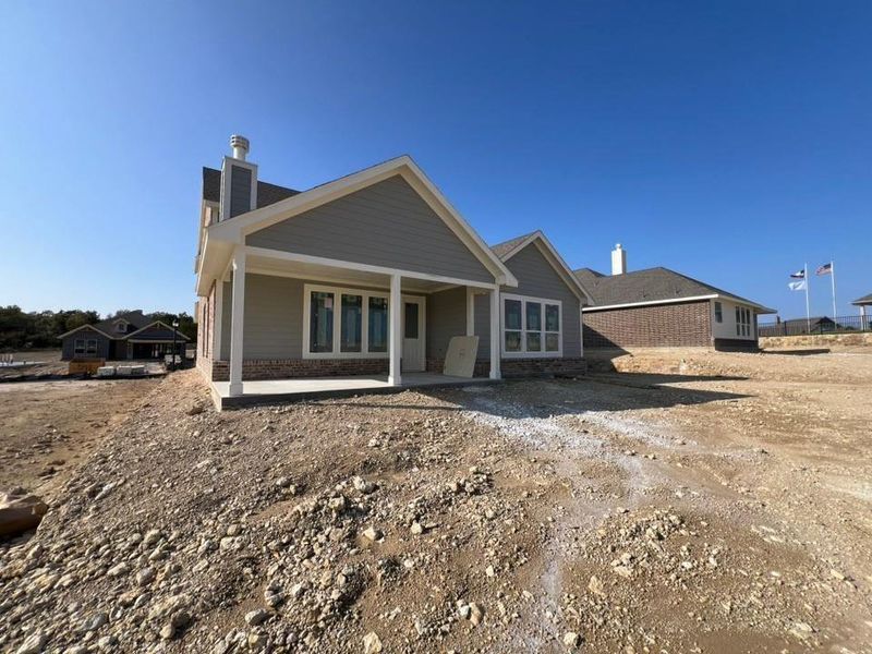 Rear view of house with a chimney, a patio area, and brick siding