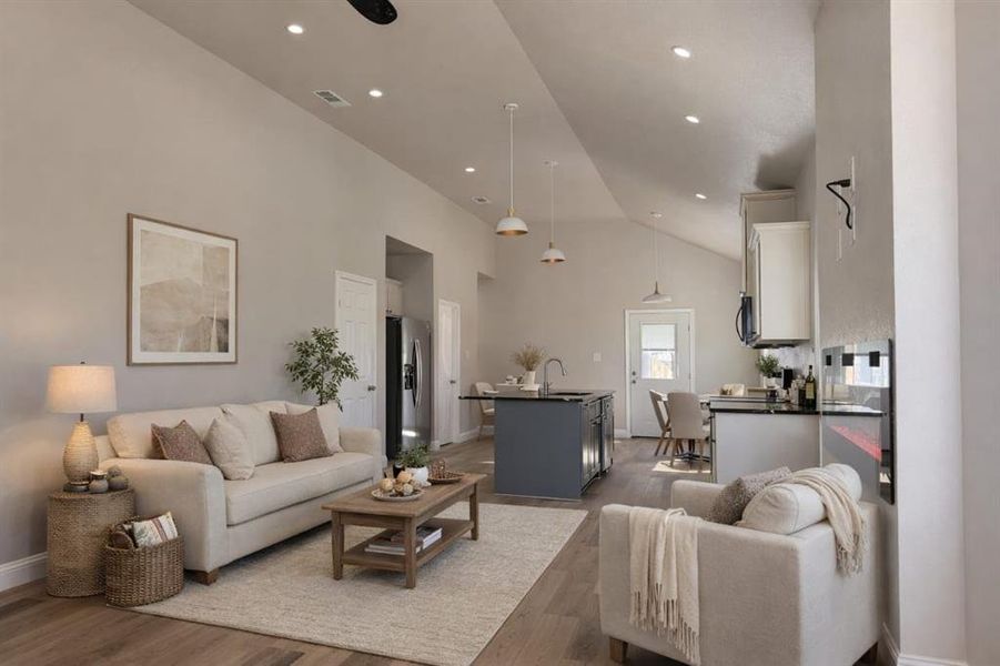 Living room with light wood-style flooring and vaulted ceiling