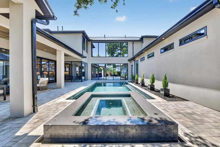 Expansive outdoor living area featuring a rectangular pool and integrated spa Expansive outdoor living area featuring a rectangular pool and integrated spa