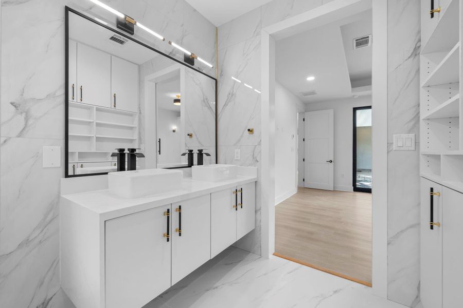 This dream master bath has dual sinks, marble floors, and a large framed mirror. This dream master bath has dual sinks, marble floors, and a large framed mirror.