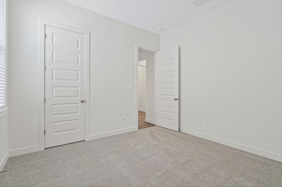 Neutral-toned room with light gray carpeting, white painted walls, and white baseboards