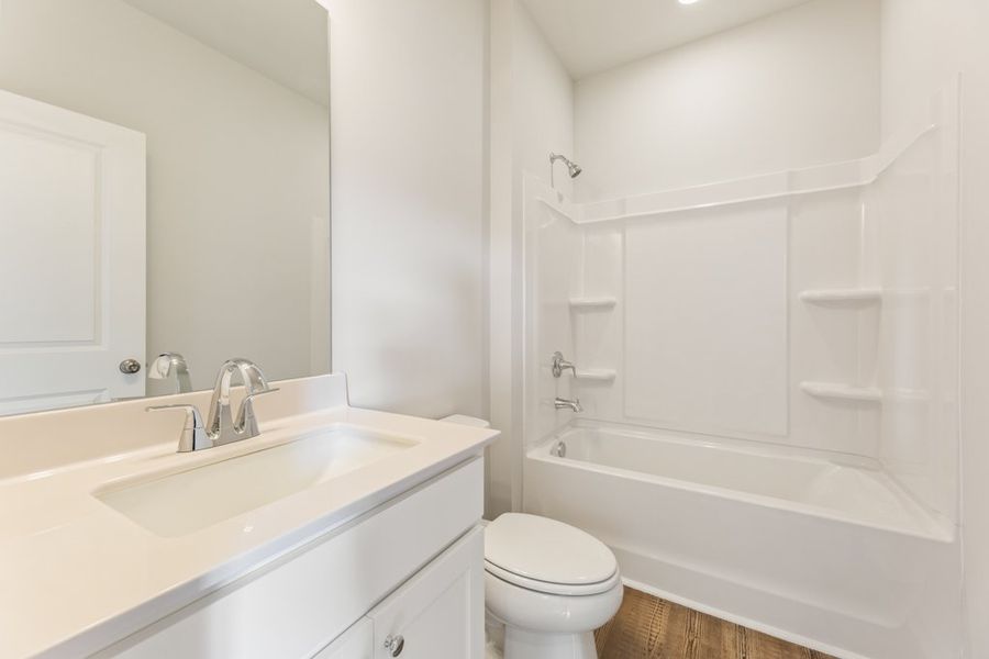 A bathroom with a tub sink and toilet.
