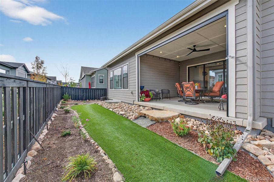 Backyard (Angle 1) – Beautifully landscaped backyard with a mix of turf and rock accents, complemented by garden beds and a privacy fence.