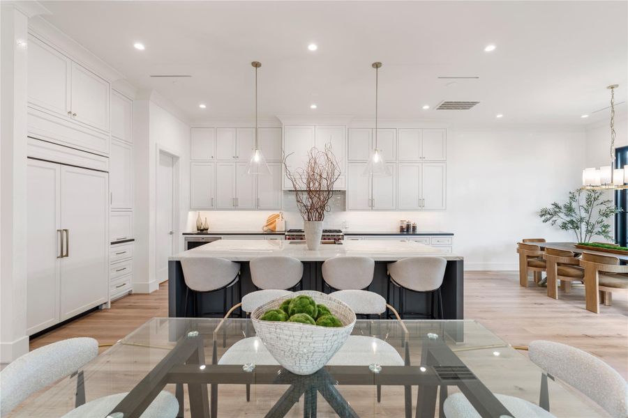 Four barstools fit at the island for casual dining, with room between the island and the living room for a breakfast table. Under-cabinet lighting and plug strips will keep the look sleek. The huge walk-in pantry is neatly tucked away to the left.
