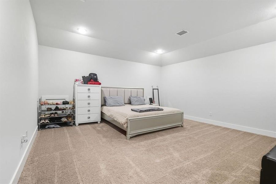 Media room currently used as bedroom featuring light colored carpet and recessed lighting Media room currently used as bedroom featuring light colored carpet and recessed lighting