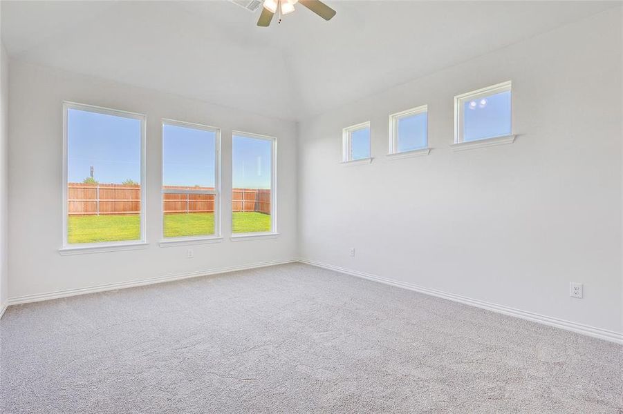 Carpeted spare room featuring ceiling fan