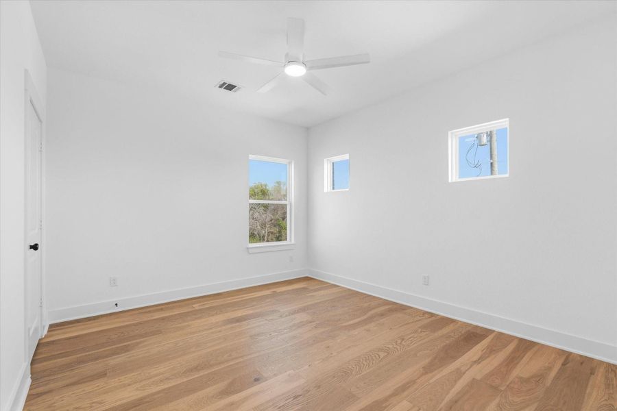 The second-floor bedroom features a ceiling fan for comfort and a spacious walk-in closet.