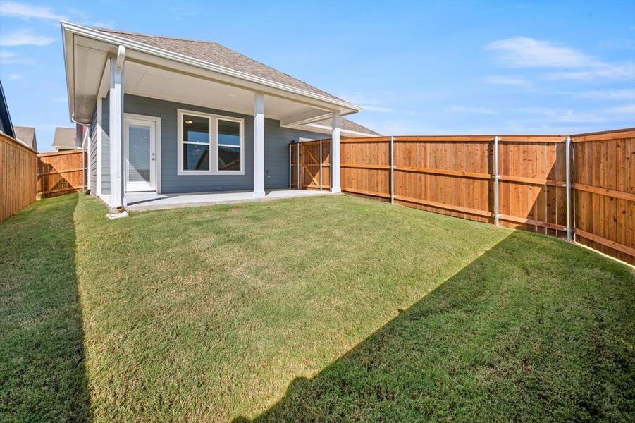 Rear view of house featuring a patio and a yard