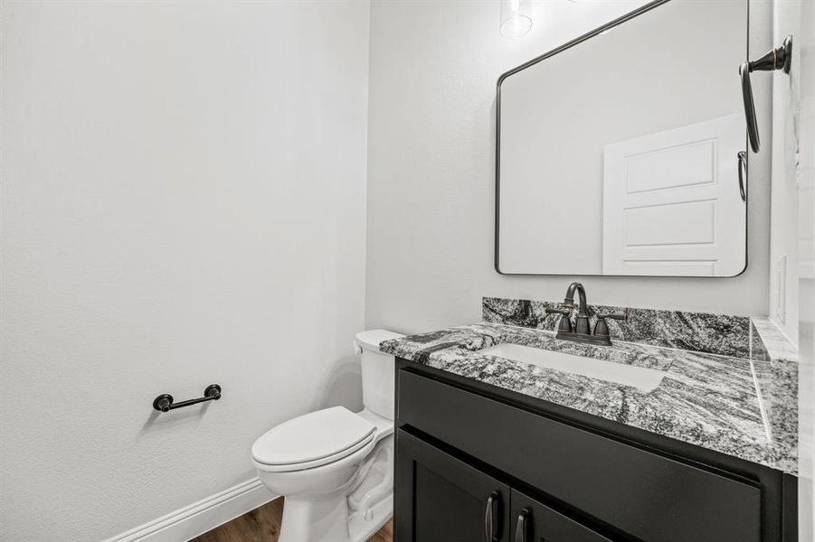 Bathroom featuring hardwood / wood-style floors, vanity, and toilet