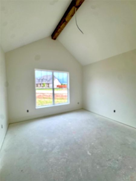 A window-filled bedroom with a vaulted ceiling and an exposed beam, awaiting your personal touch.